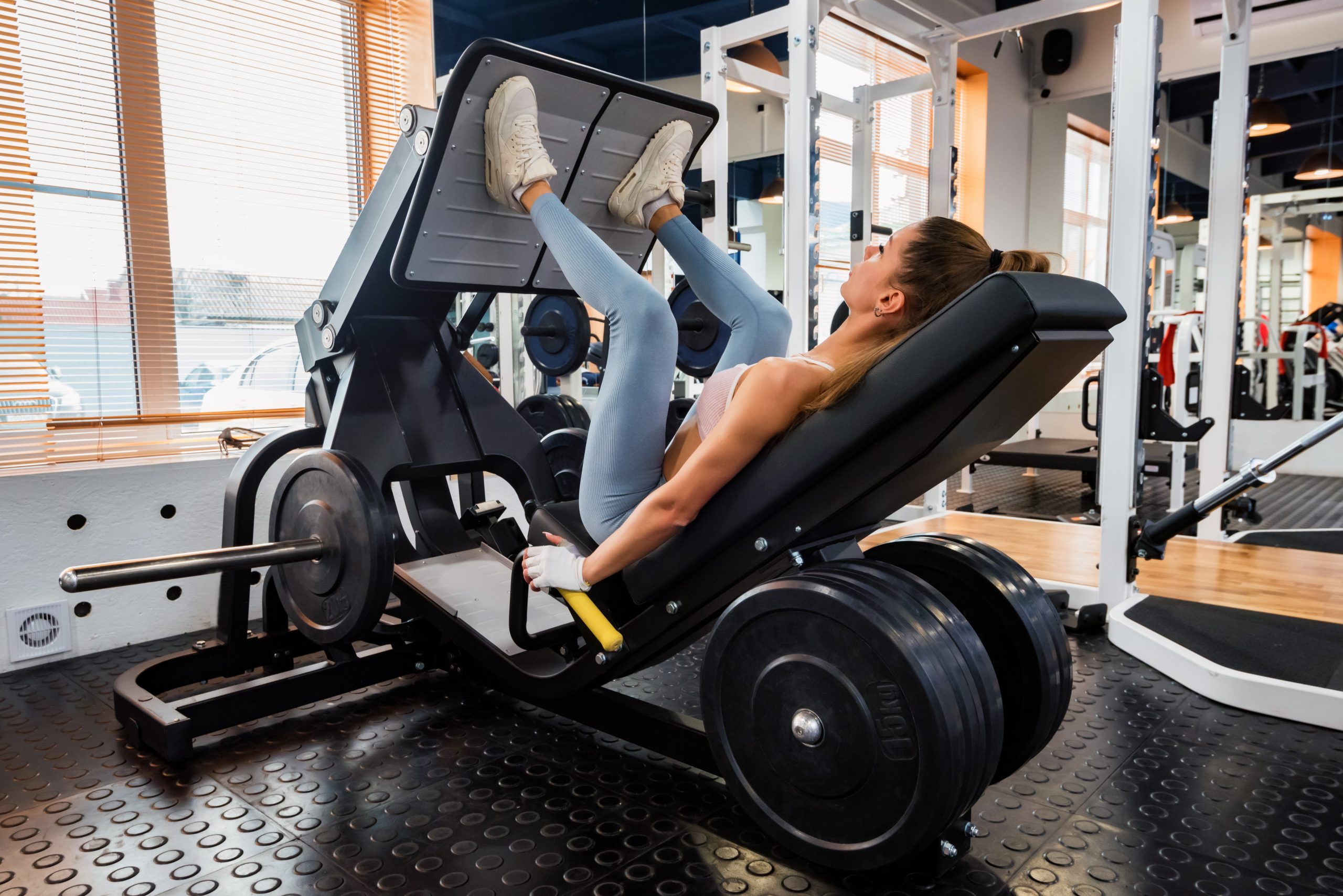 glute focused leg press tutorial woman using a leg press machine in the gym