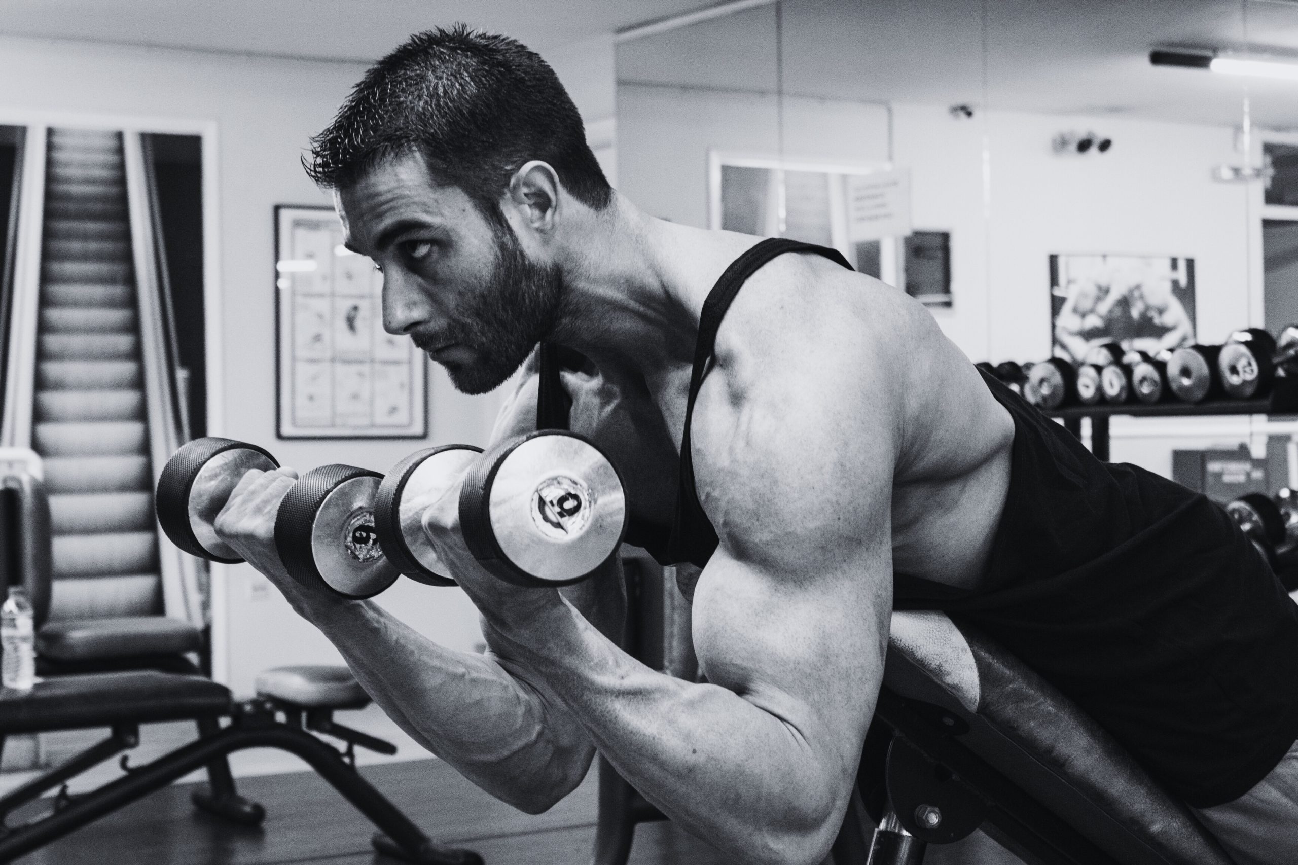 spider curl superset, man doing spider curls in a gym with dumbbells